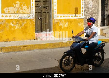 Persone su una moto che indossa maschere viso nella città di Izamal, Yucatan, Messico - durante il Covid-19 Pandemic Foto Stock