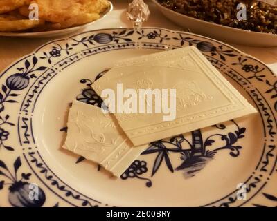 Wafer rotto della vigilia di Natale nel piatto. Cibo servito per la cena della vigilia di Natale Foto Stock