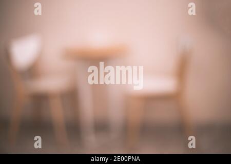 Sfondo sfocato del posto caffè con due sedie e piccolo tavolo fuori fuoco caffè o cucina giallo primo piano Foto Stock