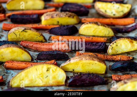 Ristorante, vegetarianismo, veloce, salute, ricette concetti - forno cotta verdure tagliate patate carote, funghi con aneto stagionante. Arrosto Foto Stock