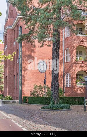 Berlino, Germania - 3 ottobre 2020: Edificio in mattoni di clinker della tenuta residenziale Paul-Francke-Siedlung costruito nel 1990 con un medaglione ritratto su t Foto Stock