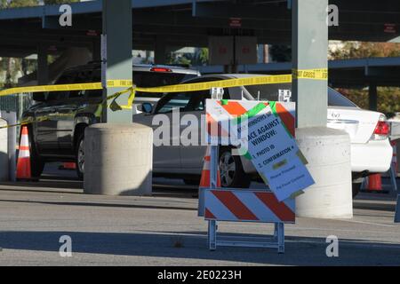 Una donna assiste gli automobilisti in un servizio drive-thrus test presso l'East Los Angeles College, venerdì 18 dicembre 2020 a Monterey Park, California (Dyl Foto Stock