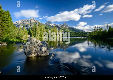 Boulder nel lago Taggart con le nuvole sbavate a Grand Teton Parco nazionale Foto Stock