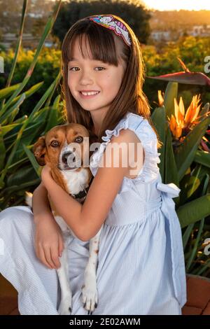 Ragazza di sette anni che tiene il suo animale domestico del cane Foto Stock