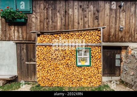 Capanna di montagna con legna da ardere in pila. Muro di legna da ardere. Sfondo di legna da ardere tagliata a secco in cottage.Wood per winter.Rural lifestyle.pile di legna da ardere Foto Stock