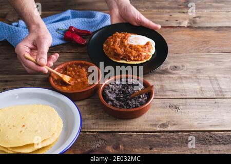 Processo di produzione di uova per la colazione messicane per gli allevatori su una base di legno. Cucina messicana. Spazio di copia. Foto Stock