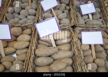 Vista dall'alto, vari tipi di patate vendono su cestini di rattan di fronte al negozio di alimentari esterno. Foto Stock