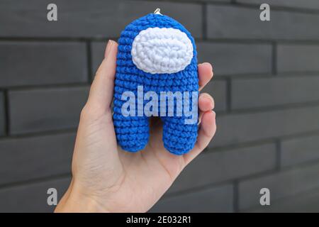 Crochet giocattolo membro equipaggio tra noi blu Impostor in ragazza mano Foto Stock