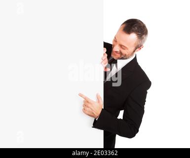 Uomo d'affari sorridente che punta al segno vuoto Foto Stock