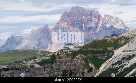 Una casa in collina; rocce dolomite in Italia Foto Stock