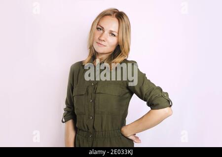 Giovane bella donna bionda con camicia verde su sfondo bianco. Isolato Foto Stock