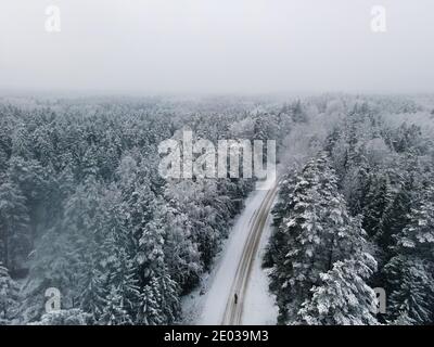Vista dall'alto della foresta di abeti rossi. Paesaggio invernale dall'alto. Colpo di drone di albero coperto di neve Foto Stock