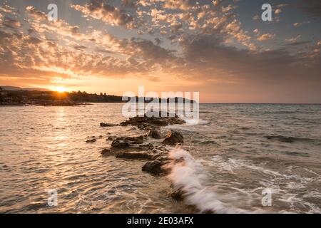 Onde schiaccianti su rocce frastagliate durante il tramonto a Tsilivi Zakinthos Grecia Foto Stock