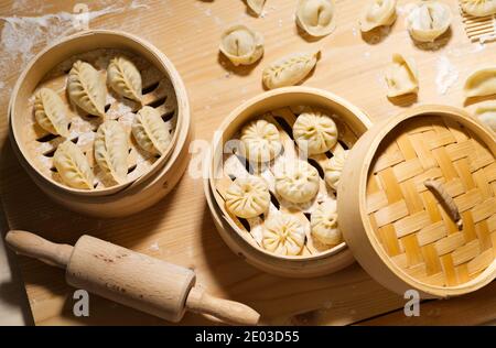 Mazzi e gnocchi in vaporiera di bambù, cibi crudi fatti a mano, spuntini cinesi fatti in casa Foto Stock
