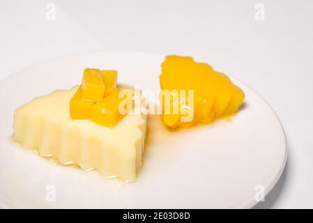 Budino fatto in casa e budino di cocco. Dessert di frutta con mango su sfondo bianco Foto Stock