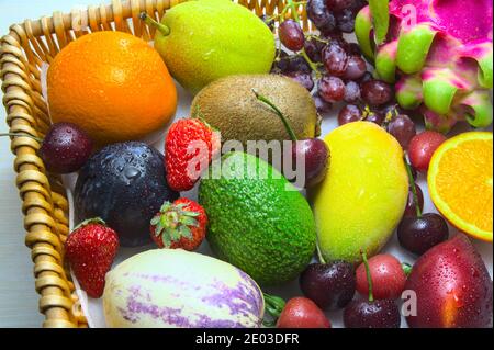 Pesca colorata, arancia, uva, fragola, frutti biologici sani nel cesto Foto Stock