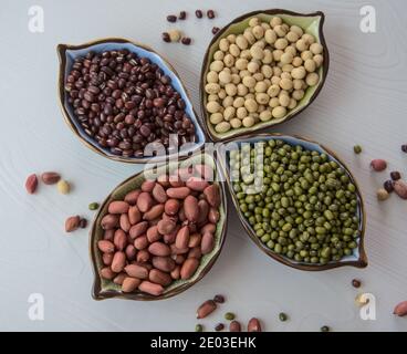 Collezione di fagioli, legumi su ciotola in ceramica su sfondo bianco di legno Foto Stock