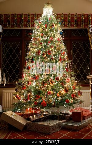 Tradizionale UK Home albero di Natale con regali sotto Foto Stock