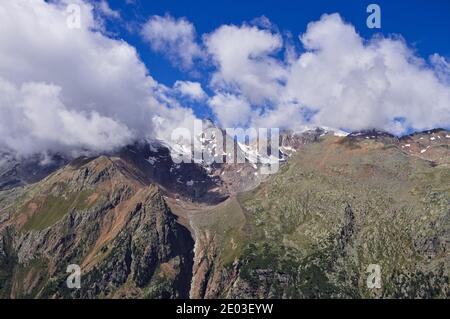 Una montagna innevata circondata da nuvole nelle Alpi italiane (Trentino, Italia, Europa)