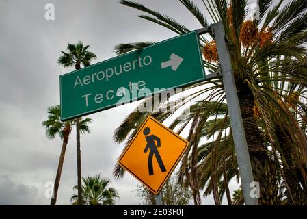 Tijuana, Messico - 30 Ottobre 2017: Cartello di accesso pedonale a forma di diamante giallo con cartello verde che indica la direzione per l'Aeroporto Tecate Foto Stock