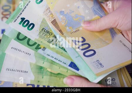 Le mani della donna tengono un mucchio di banconote in euro Foto Stock