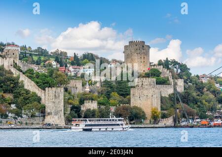 Edifici storici Castello Rumeliano presso lo stretto del Bosforo a Istanbul Turchia dal traghetto in una giornata di sole con sfondo nuvoloso cielo Foto Stock