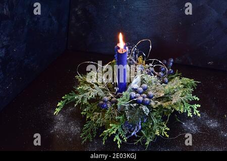 Decorazione di Natale con candele in colori blu-verde su sfondo nero. Foto Stock