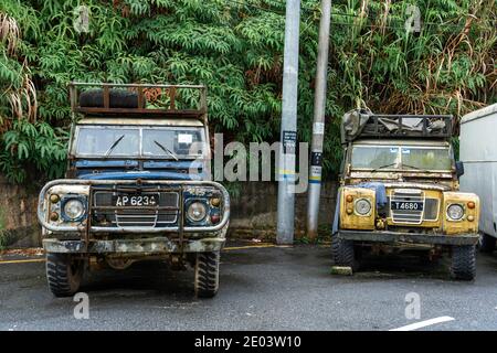 Due vecchi camion di vernice sbucciati in un villaggio asiatico. Foto Stock