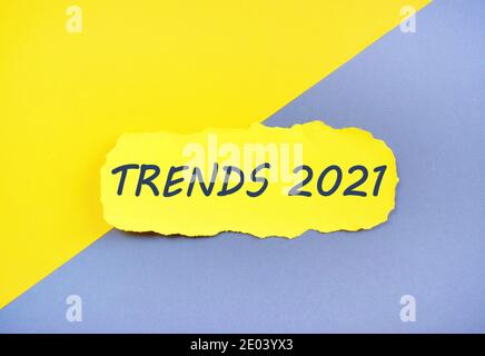 Scrittura a mano testo scrittura tendenze 2021 su carta strappata, colorata. Concetto per 2021 trend su sfondo giallo e grigio Foto Stock