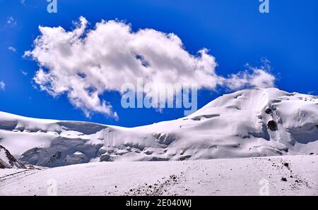 Ghiacciai di montagna giganti contro un cielo blu con nuvole Foto Stock