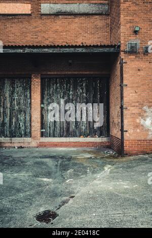 Barre di carico inutilizzate con vecchie ante in metallo corrugato Foto Stock