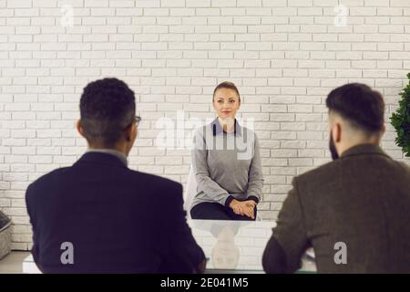 Gli ufficiali di HR intervistano la giovane donna e le pongono le sue domande circa esperienza di lavoro Foto Stock