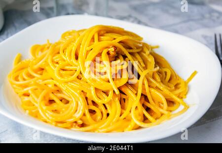 Ampia porzione di spaghetti carbonara in un piatto bianco. Cucina italiana. Cucina tipica romana. Foto Stock