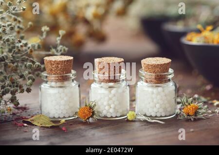 Bottiglie di globuli omeopatici ed erbe medicinali. Concetto di medicina dell'omeopatia. Foto Stock