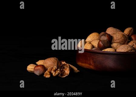 Frutta a guscio mista biologica con ciotola in legno Foto Stock