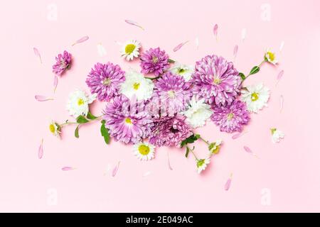 Composizione dei fiori. Layout creativo realizzato con fiori bianchi e violetti su sfondo rosa pastello. Disposizione piatta. Concetto minimo di primavera. Foto Stock