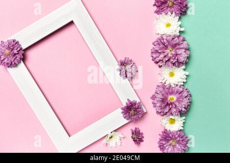 Composizione dei fiori. Cornice fotografica vuota e fiori su sfondo rosa e verde pastello. Giorno di San Valentino, giorno delle madri, giorno delle donne, concetto di primavera. Piatto Foto Stock