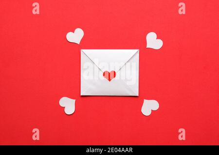 Carta valentina bianca con cuore rosso su sfondo rosso. Foto Stock