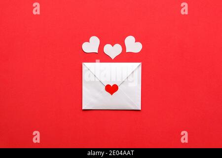 Lettera di San Valentino su sfondo rosso. Cuori bianchi sopra. Foto Stock