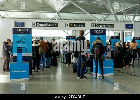 Passeggeri e viaggiatori che attraversano i cancelli di partenza dell'aeroporto di Londra Stansted Essex Inghilterra Regno Unito Regno Unito Foto Stock