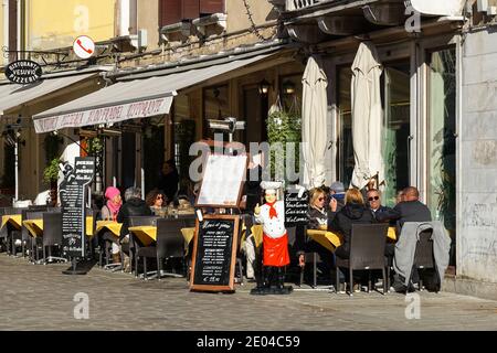 Persone sedute fuori ristorante nel sestiere di Cannaregio, Venezia, Italia Foto Stock