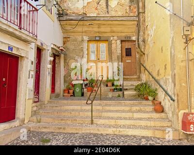 Scalinata tipica e vecchie case tradizionali con porte colorate nel quartiere di Alfama, nella città di Lisbona, Portogallo Foto Stock