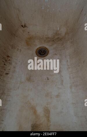 Molto vecchio bagno di shabby arrugginito da vicino. Un bagno con smalto bianco peeling vecchia vasca sporca. Una vecchia vasca sporca con un tocco di ruggine Foto Stock