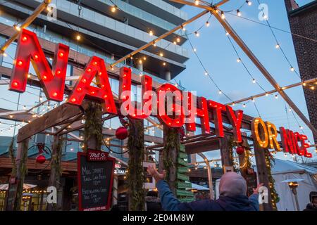 Un cartello illuminato di rosso che legge Naughty o Nice in un bar all'aperto presso il mercato di Natale del quartiere della distilleria di Toronto Foto Stock