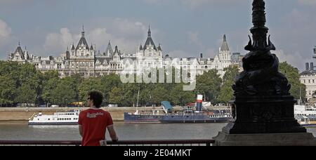 GRAN BRETAGNA / Londra / turista che guarda la vista dalla Southbank attraverso il Tamigi ed è bella vecchia architettura lungo la Victoria Embank. Foto Stock