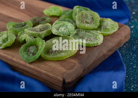 Fette secche di kiwi su tavola di legno Foto Stock