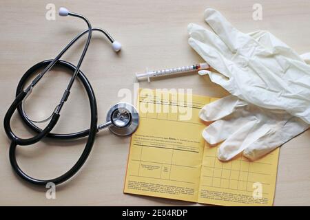 Vaccinazioni contro morbillo, parotite e rosolia con tessera di vaccinazione, siringa e guanti Foto Stock