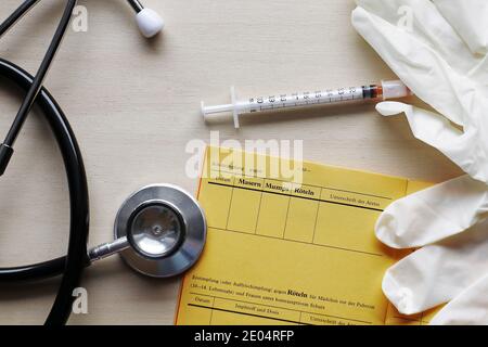 Vaccinazioni contro morbillo, parotite e rosolia con tessera di vaccinazione, siringa e guanti Foto Stock