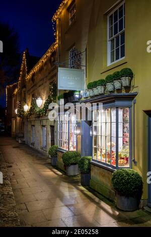 La Covent Garden Academy of Flowers lungo la strada principale con le luci di natale all'alba. Chipping Campden, Cotswolds, Gloucestershire, Inghilterra Foto Stock