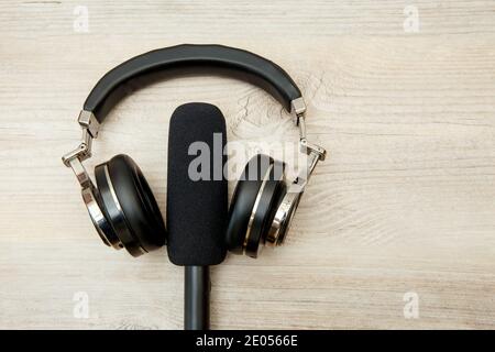 Cuffie e microfono wireless su un tavolo di legno. Foto Stock